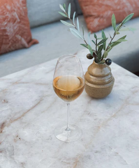 a glass of wine sitting on top of a marble table