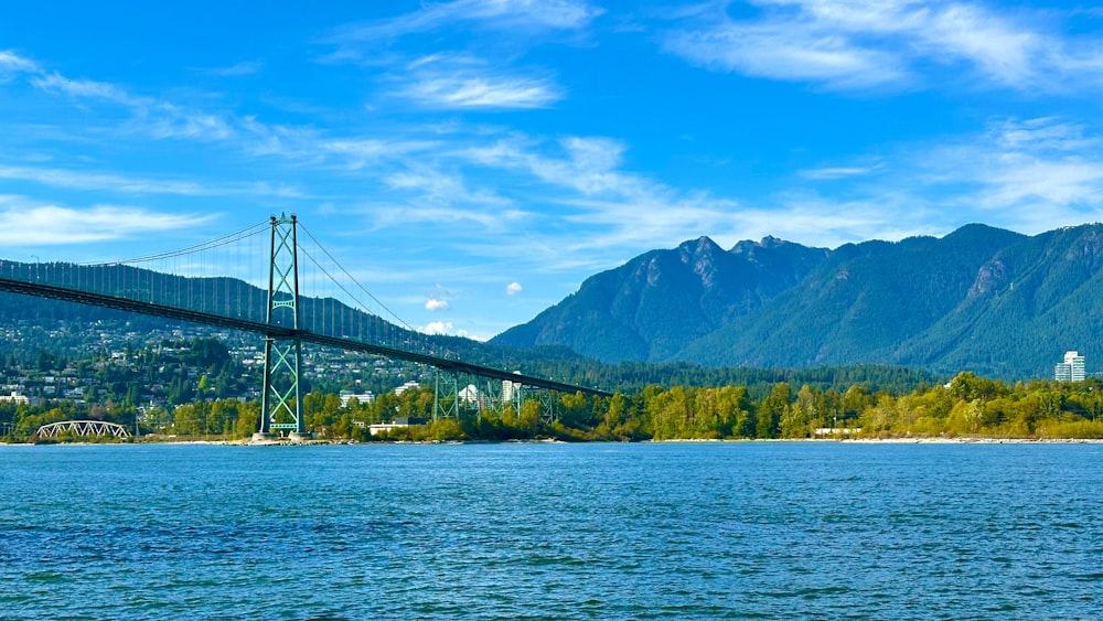 a bridge over a body of water with mountains in the background