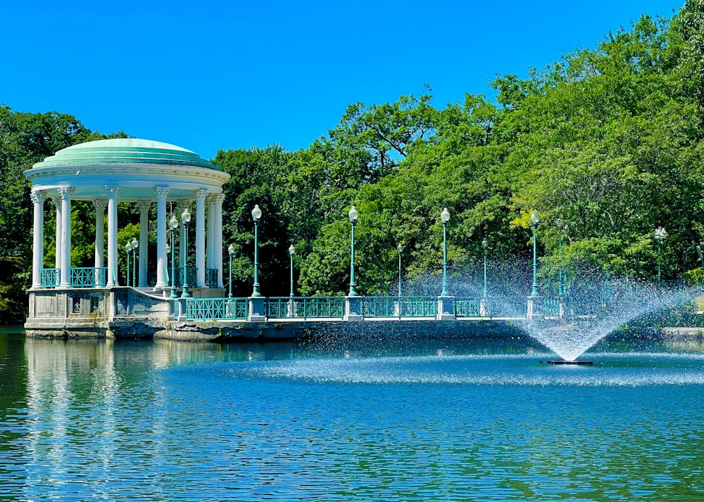 a gazebo in the middle of a lake surrounded by trees