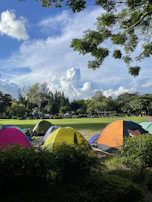 Volunteers setting up colorful tents and tables under a bright blue sky.