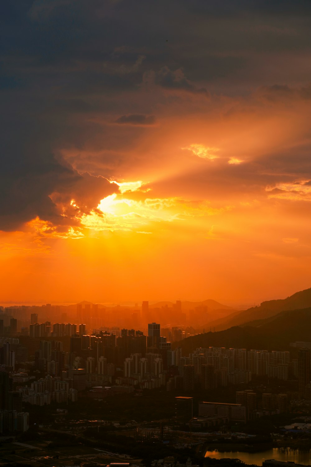 the sun is setting over a city with tall buildings