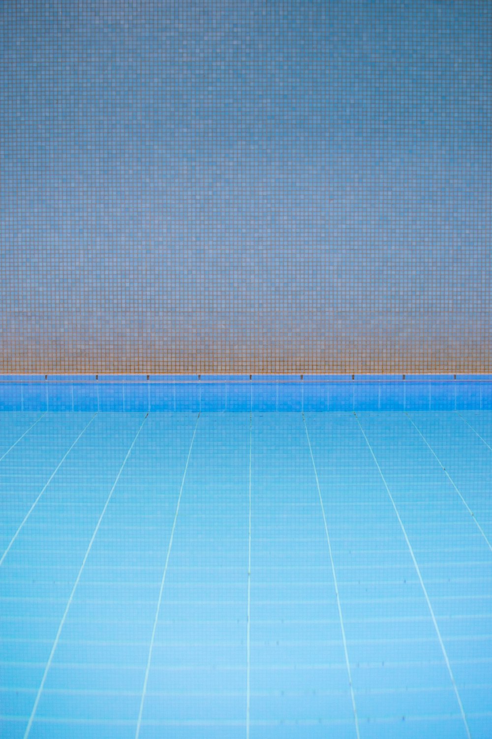 青いタイル張りの床の空のスイミングプール