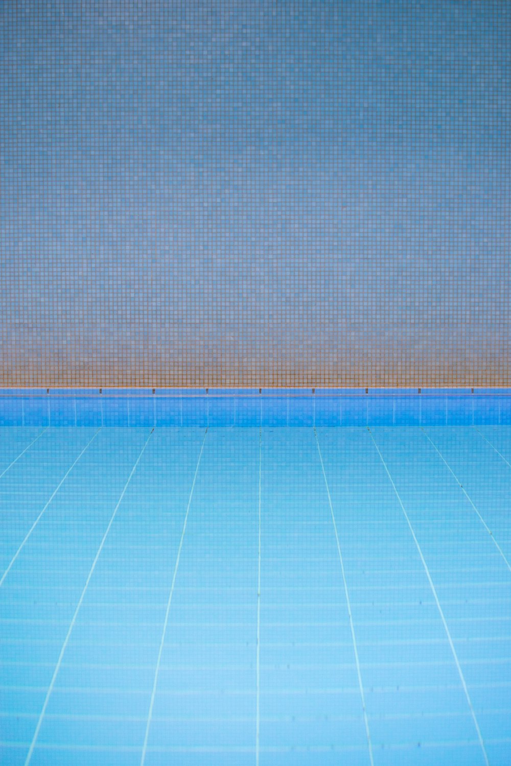 an empty swimming pool with a blue tiled floor