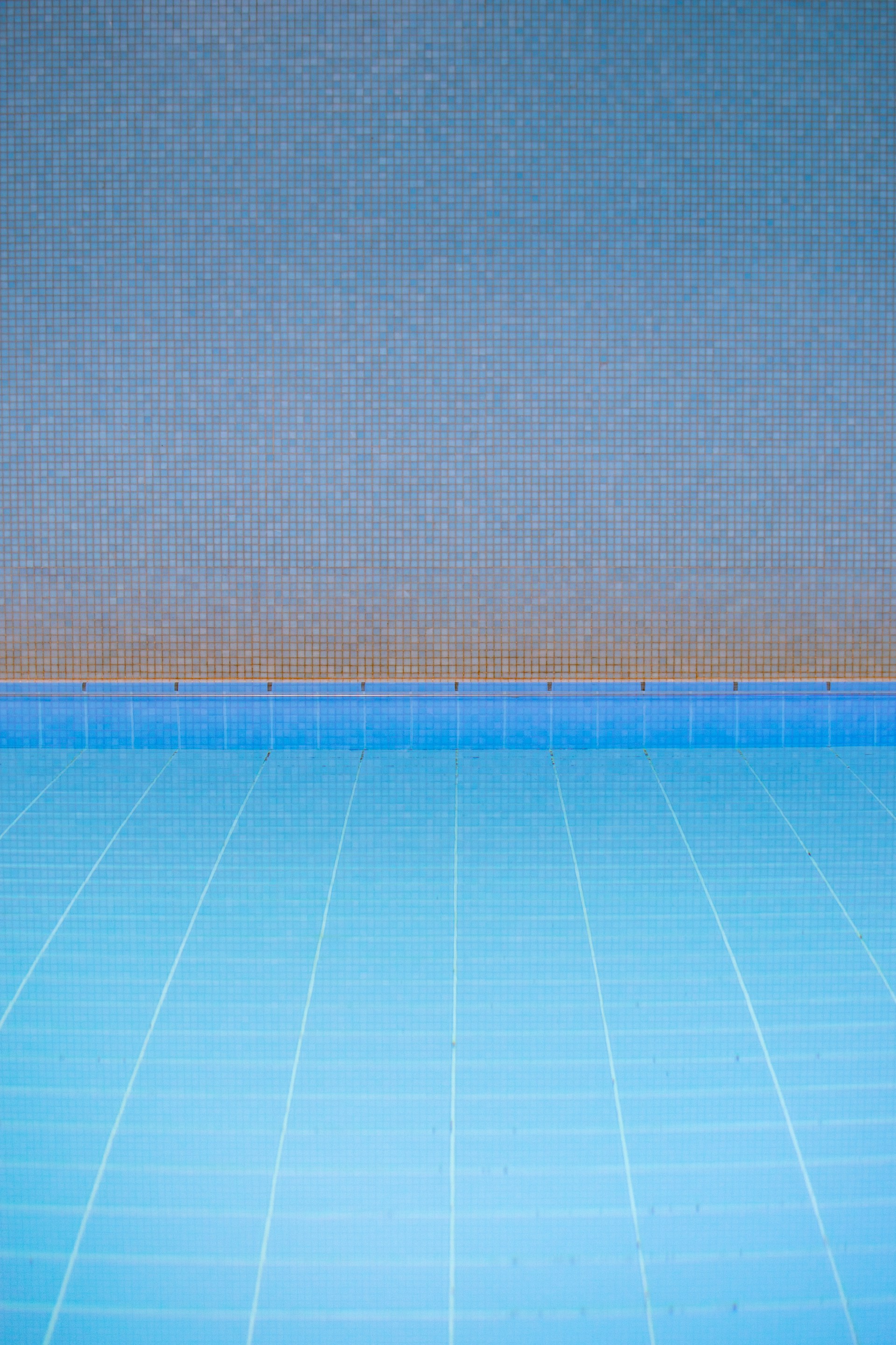 an empty swimming pool with a blue tiled floor