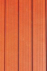 Four vertically aligned wooden planks with a rich brown color. Each plank has evenly spaced grooves running lengthwise, providing a textured appearance. Subtle variations in shade and grain are visible across the surface.