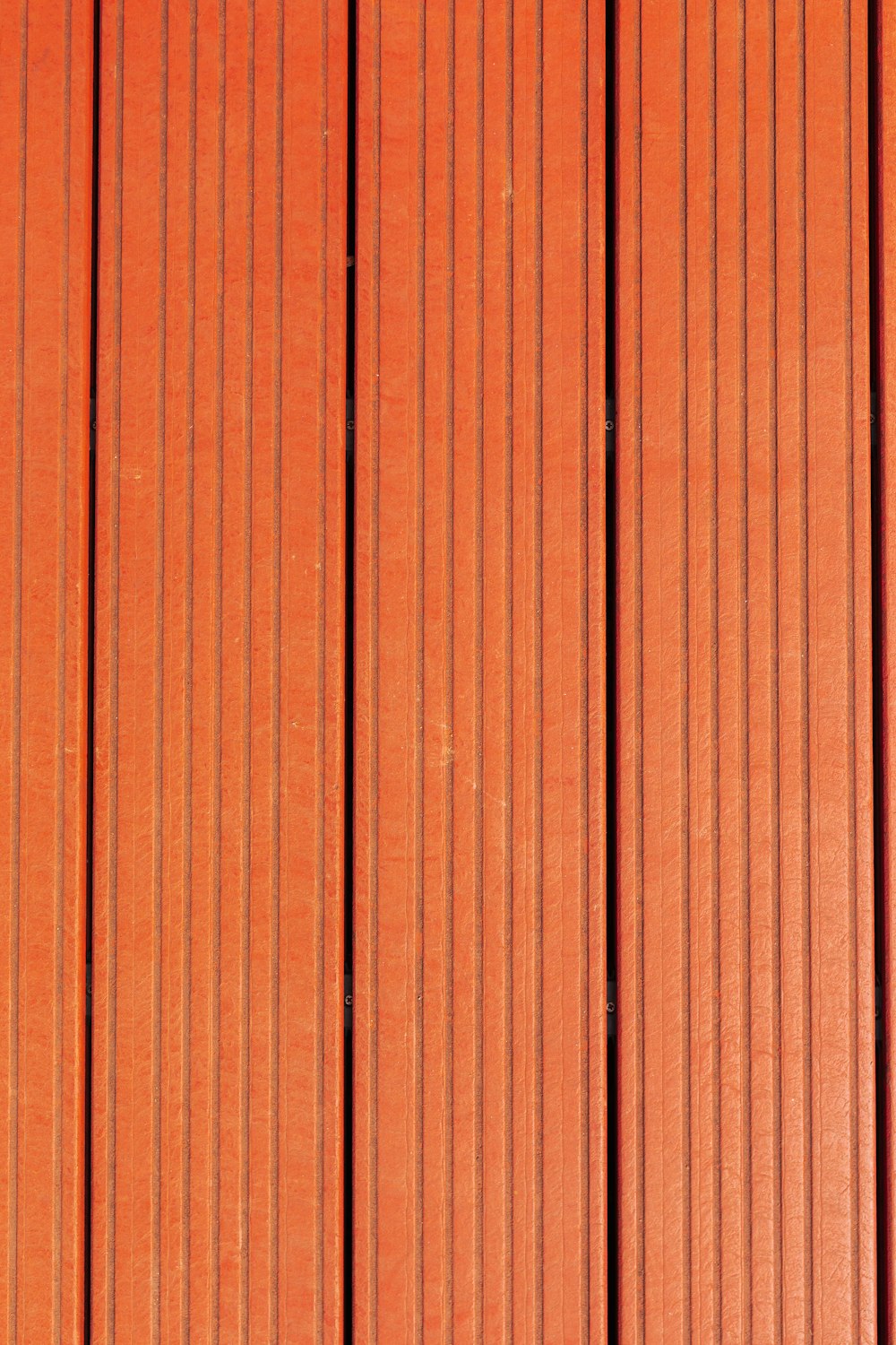 a close up of a red wall with vertical lines