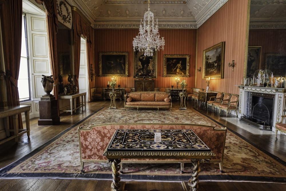 a living room with a chandelier, couch, and fireplace