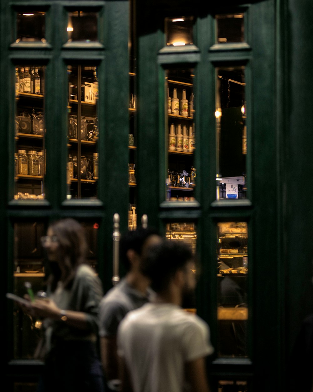 a group of people standing in front of a green door