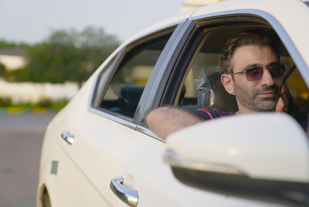 a man sitting in a car talking on a cell phone