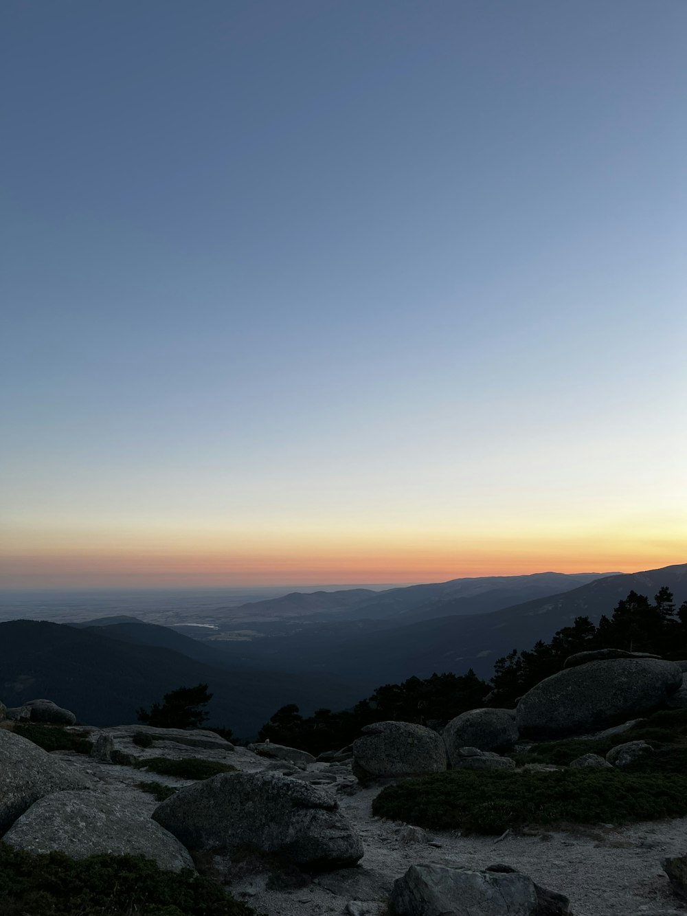 a person standing on top of a mountain at sunset