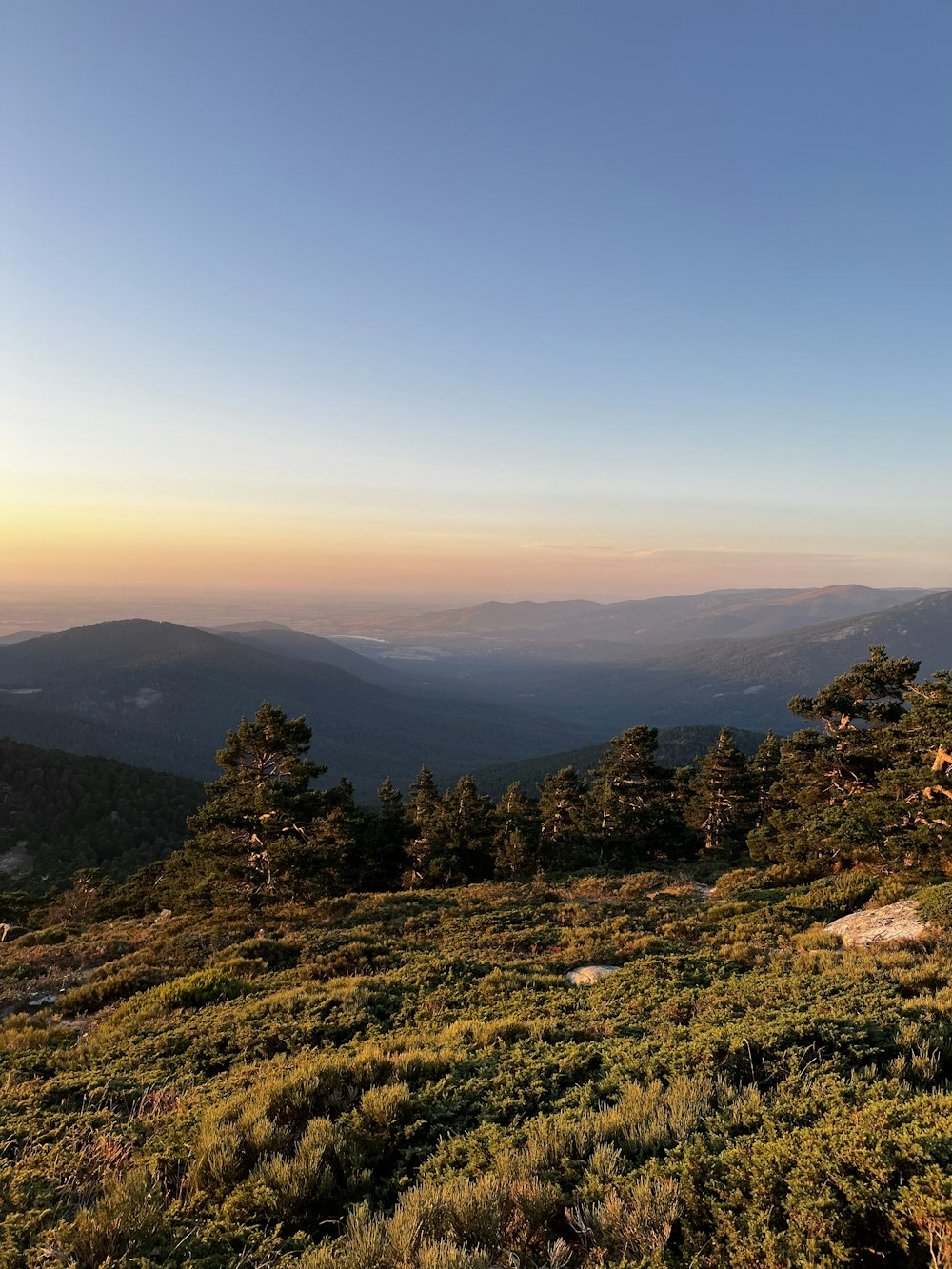 the sun is setting over the mountains in the distance