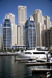 Luxury waterfront residences overlooking yachts docked in Dubai Marina under a clear blue sky.