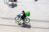 Courier riding a bike through city streets with a delivery bag.
