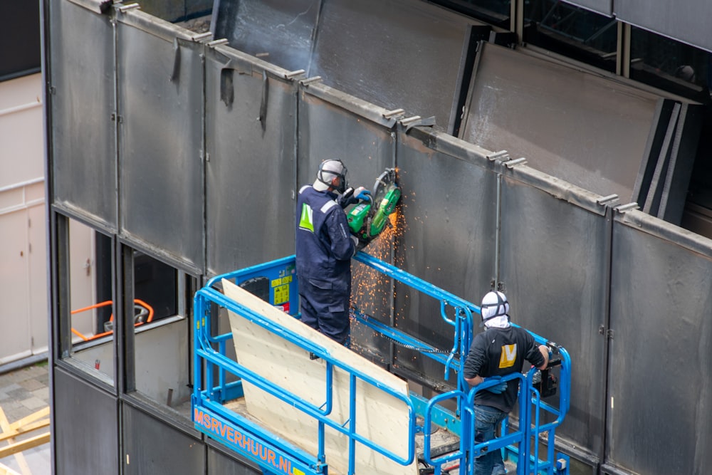 a couple of men standing on top of a metal structure