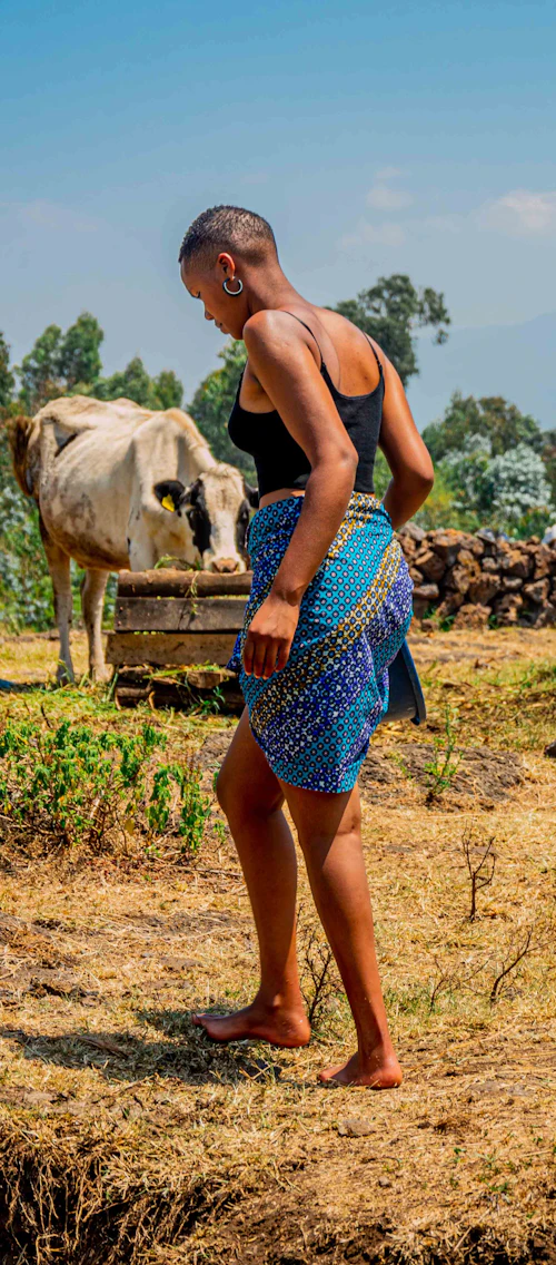 Woman walking through a green field in Musanze, Rwanda