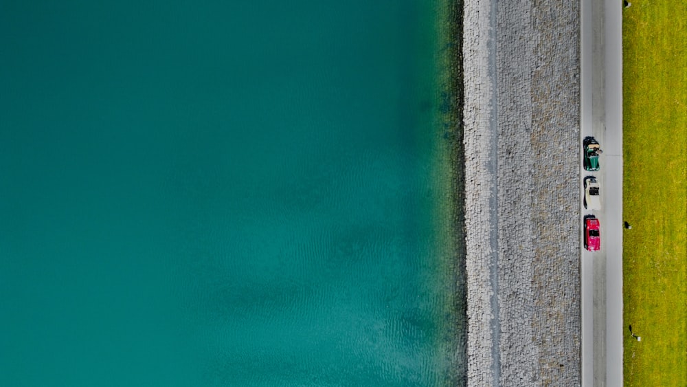 a car driving down a road next to a body of water