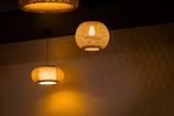 Elegant wall lights with woven rattan shades glowing softly at dusk.