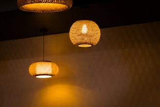 Elegant wall lights with woven rattan shades illuminating a softly lit hallway.