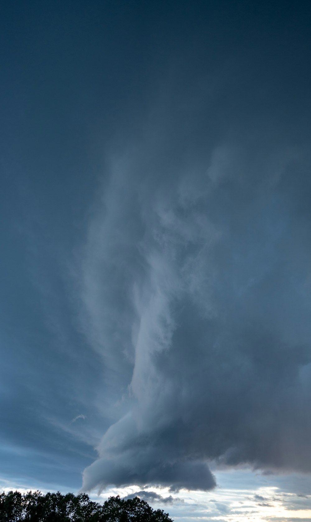 a large cloud is in the sky over a field