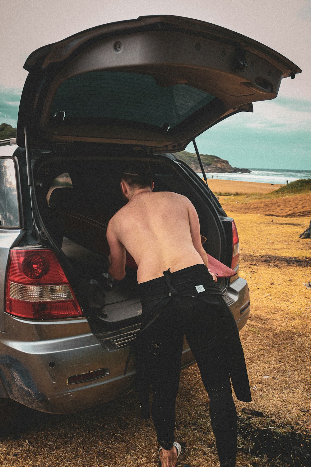 a man standing in the trunk of a car