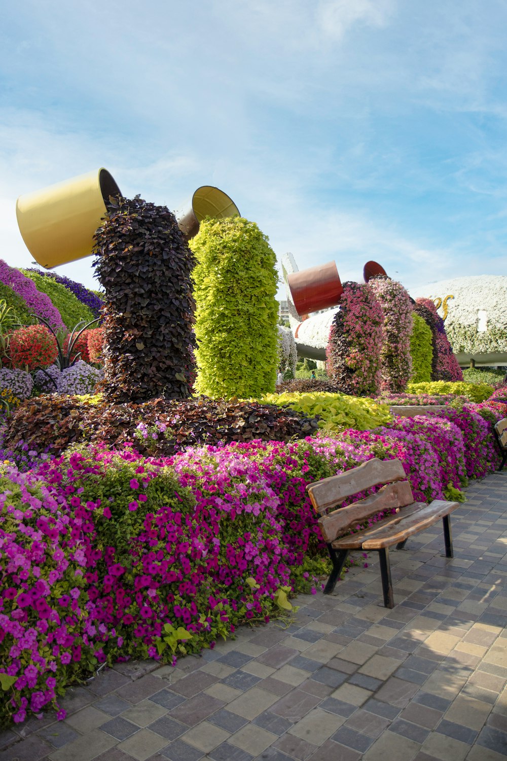 a wooden bench sitting in front of a flower garden