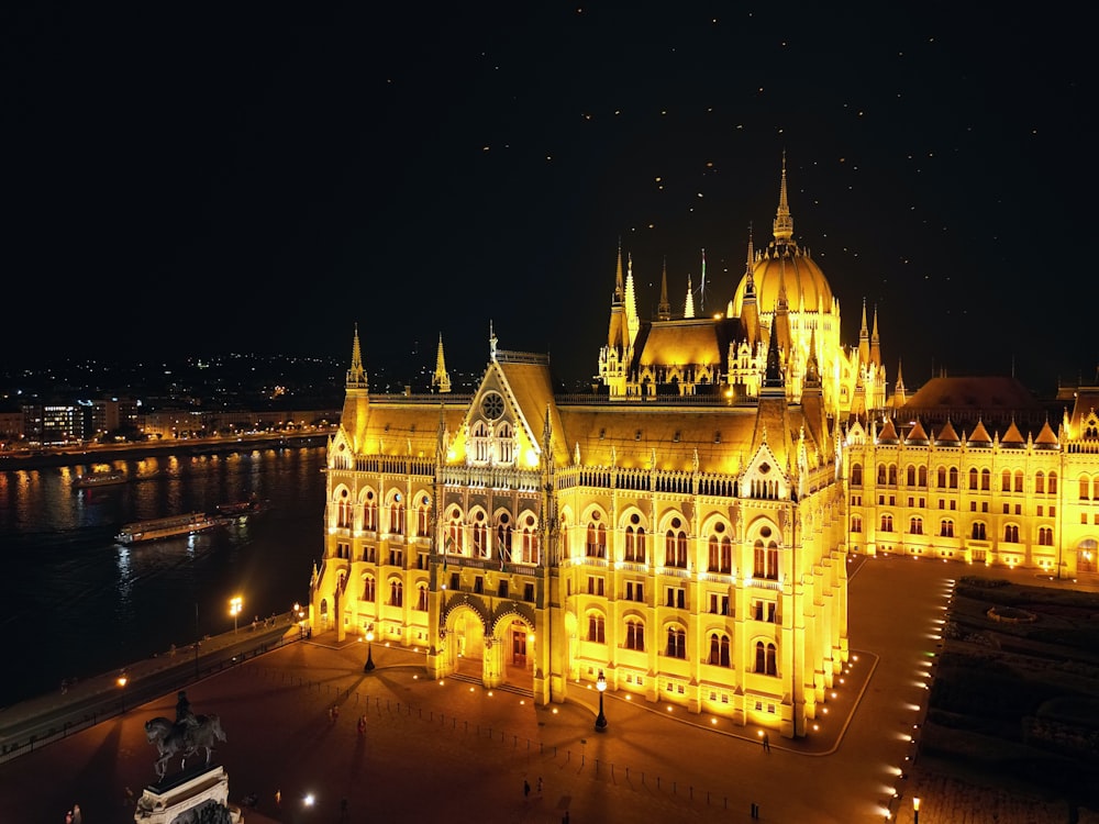 a large building lit up at night next to a body of water