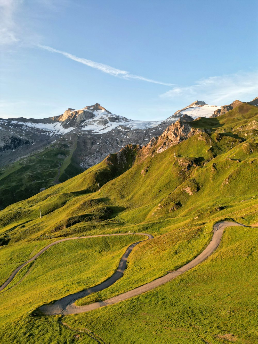 a winding road in the middle of a lush green hillside