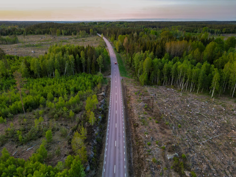 an aerial view of a road in the middle of a forest