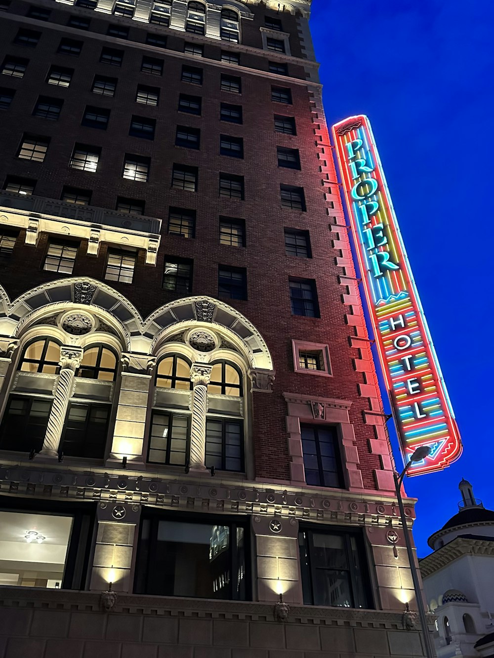 a tall building with a neon sign on it's side