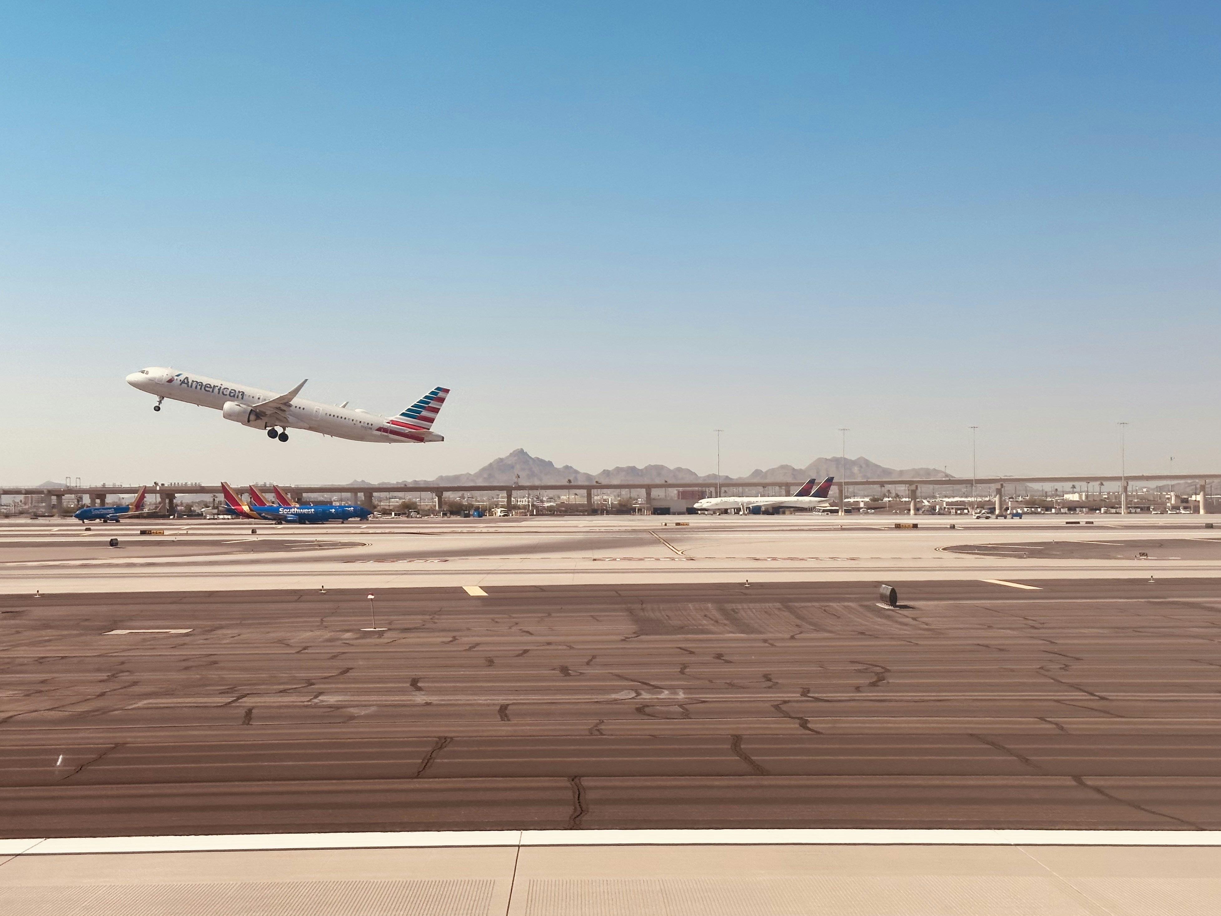 an airplane taking off from an airport runway, AA @ PHX / May 2023