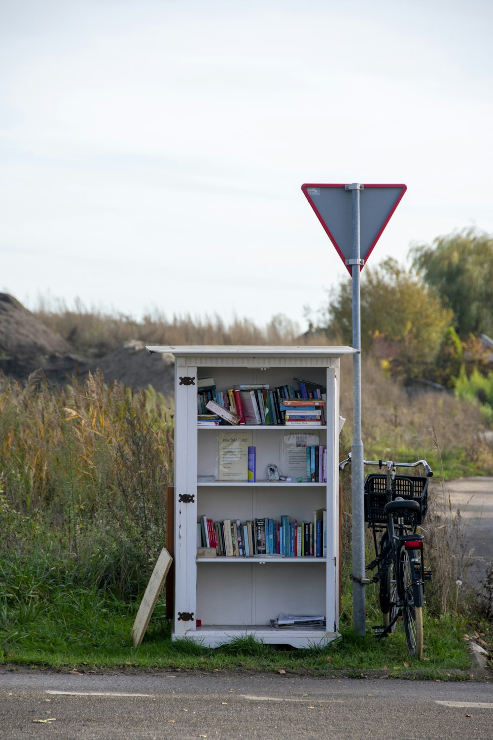 a book shelf next to a street sign and a bicycle