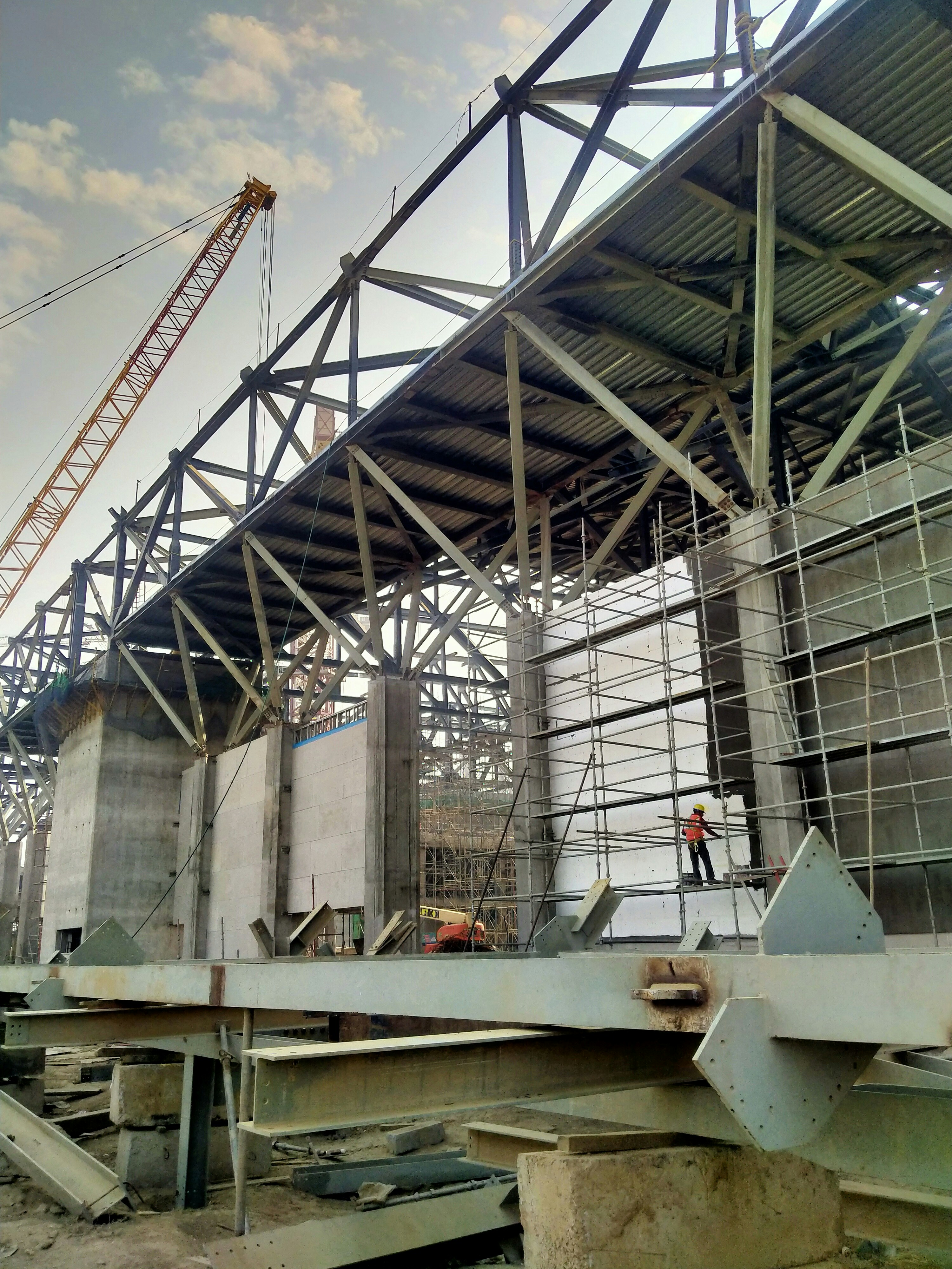 Commercial steel frame construction site with exposed I-beams against overcast sky