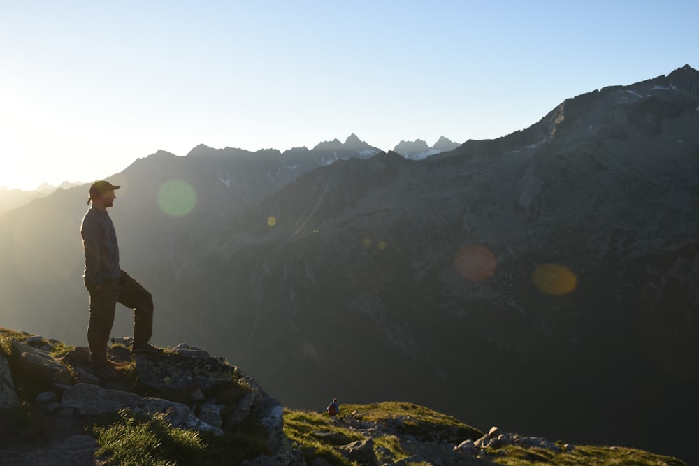 a man standing on top of a lush green hillside