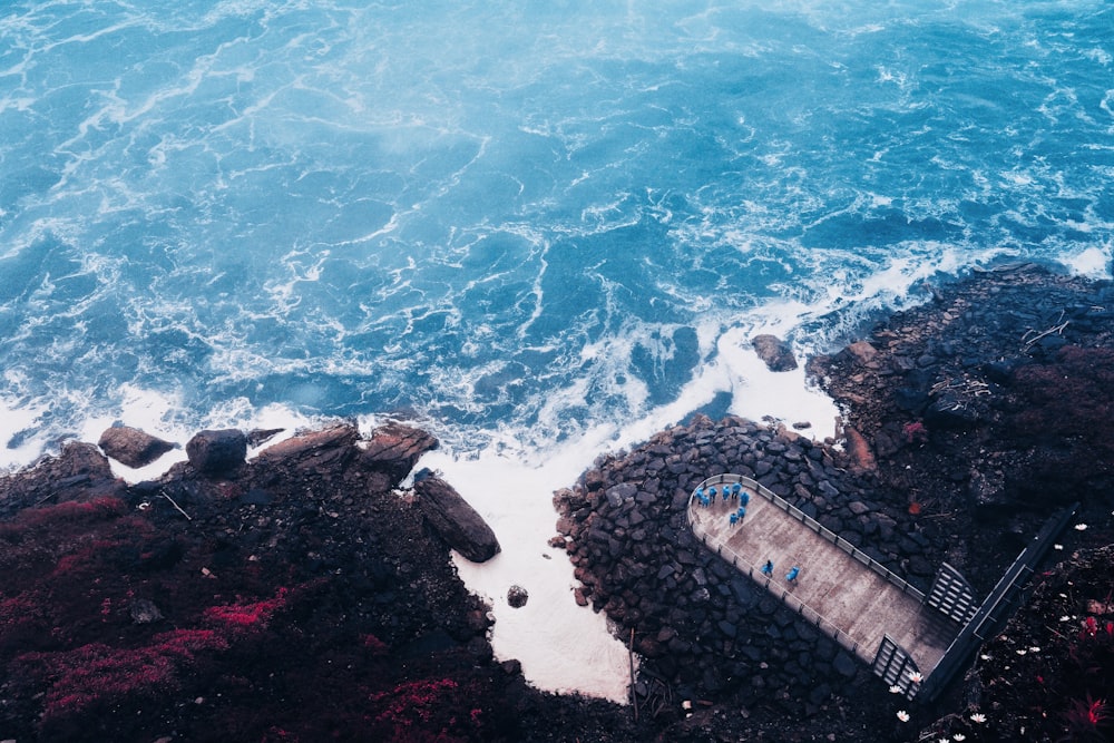 an aerial view of the ocean and rocky shore