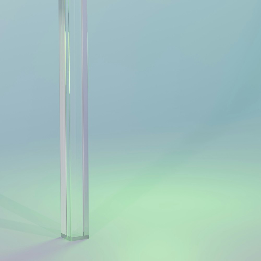 un grand tube de verre avec un plateau blanc sur fond bleu et vert