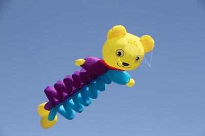 The little bear with a gentle smile, releasing a balloon into the sky.