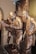 Bronze statues of three men in traditional attire, engrossed in examining a large map or document. The scene is set against a relief background depicting an urban environment with buildings. The expressions and body language suggest deep concentration and discussion.