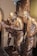 Bronze statues of three men in traditional attire, engrossed in examining a large map or document. The scene is set against a relief background depicting an urban environment with buildings. The expressions and body language suggest deep concentration and discussion.