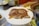 A happy customer enjoying a plate of roast duck at a restaurant.