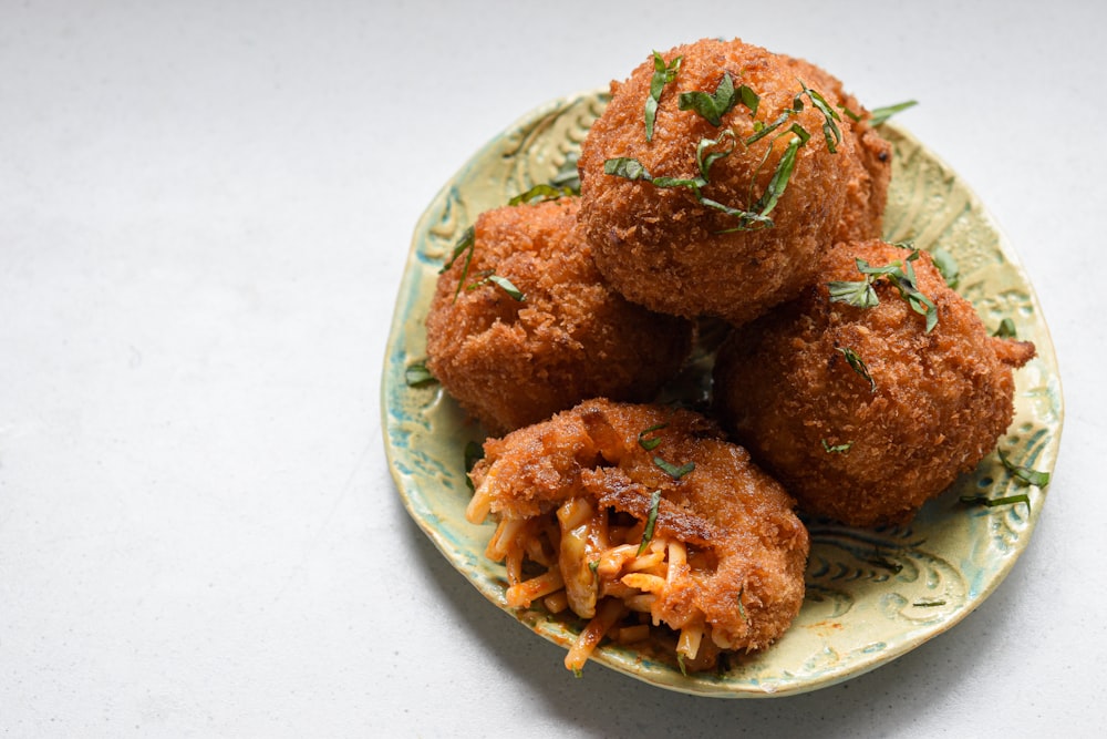 a green plate topped with fried food on top of a table