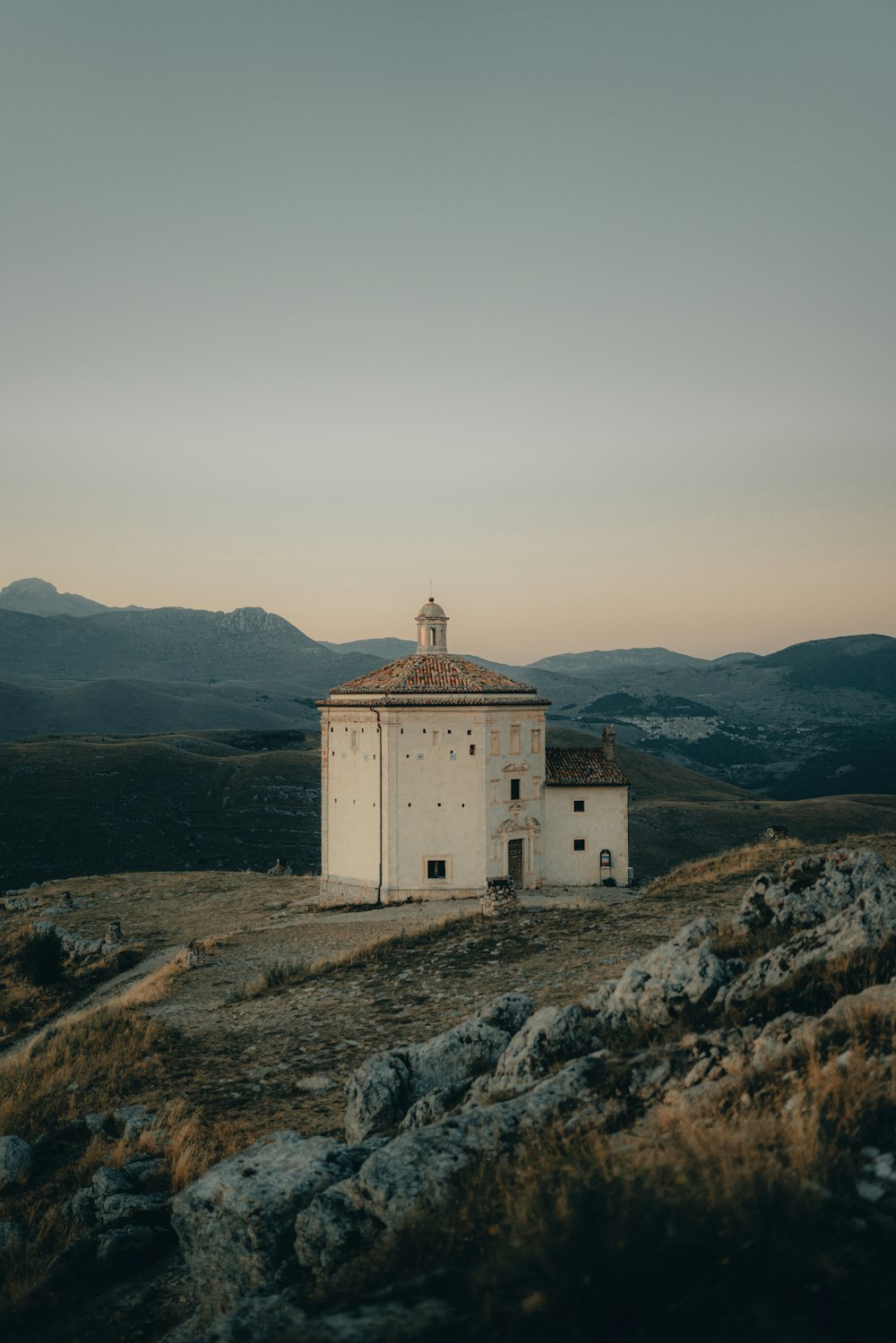 a white building sitting on top of a hill