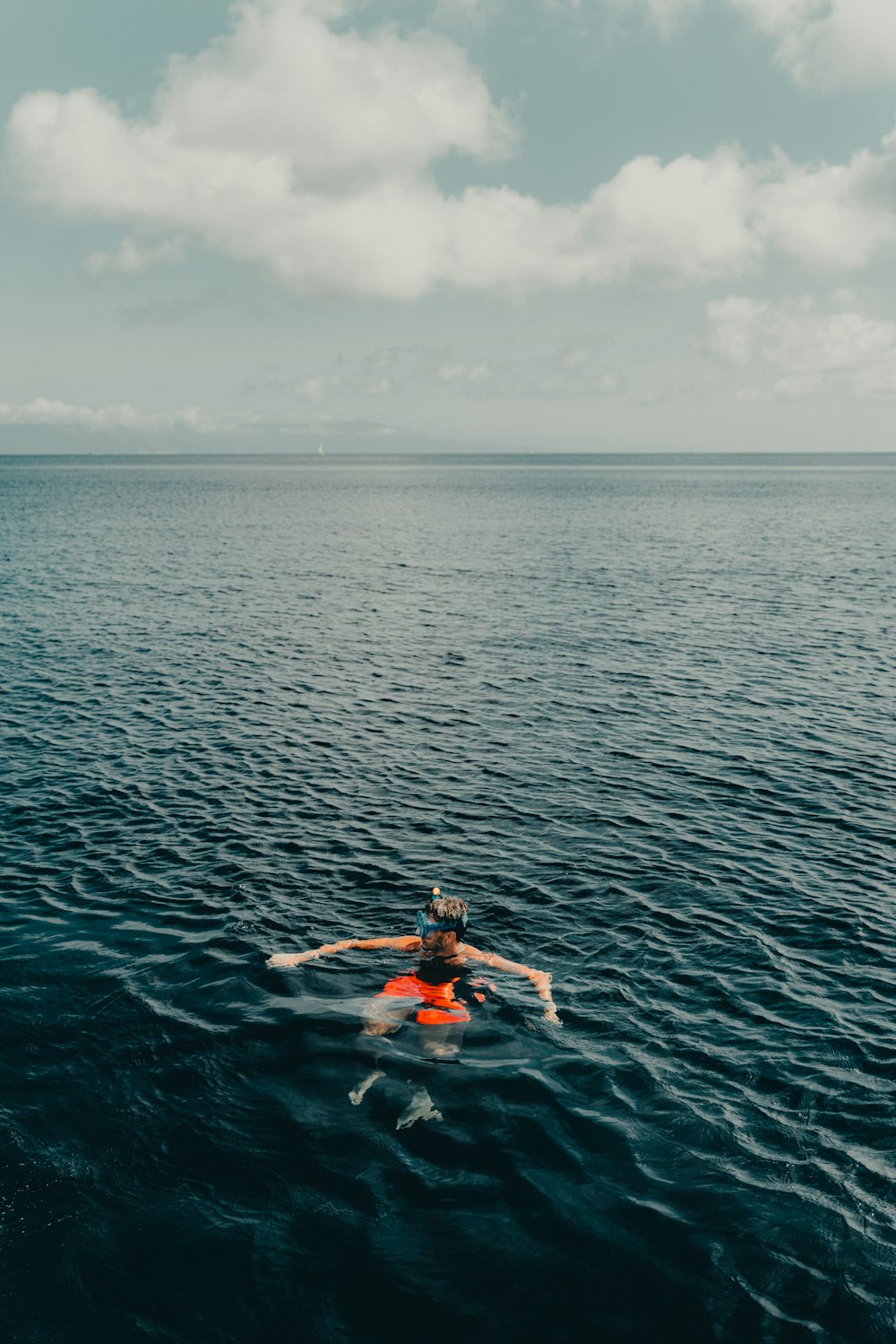 Una persona en una tabla de surf en medio del océano