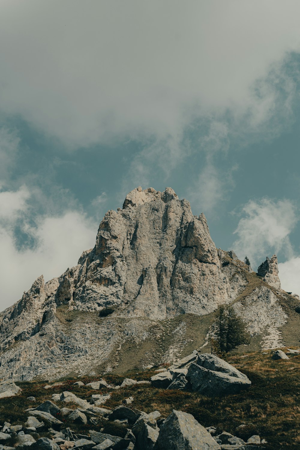 a rocky mountain with a few clouds in the sky