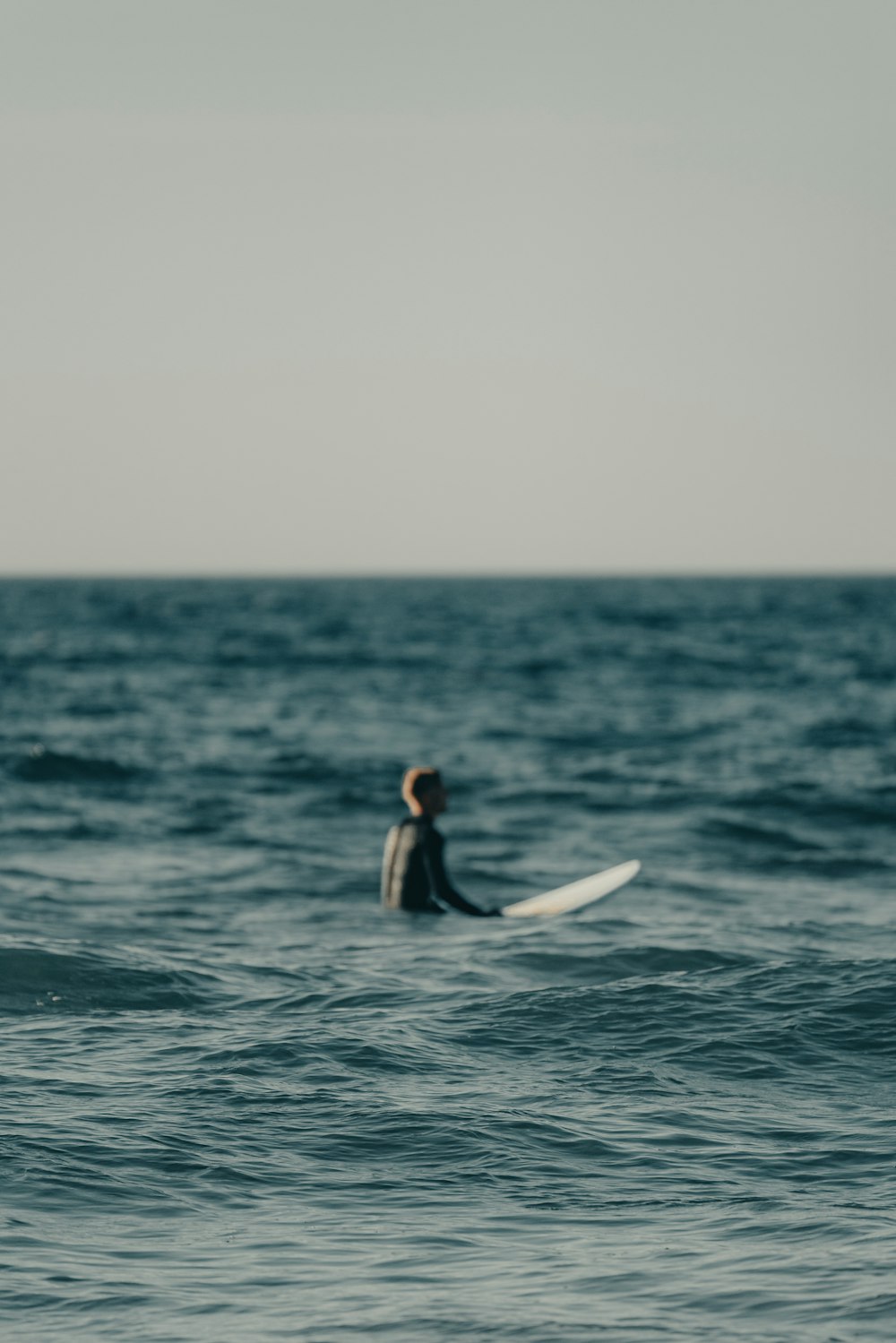 a man riding a surfboard on top of a body of water