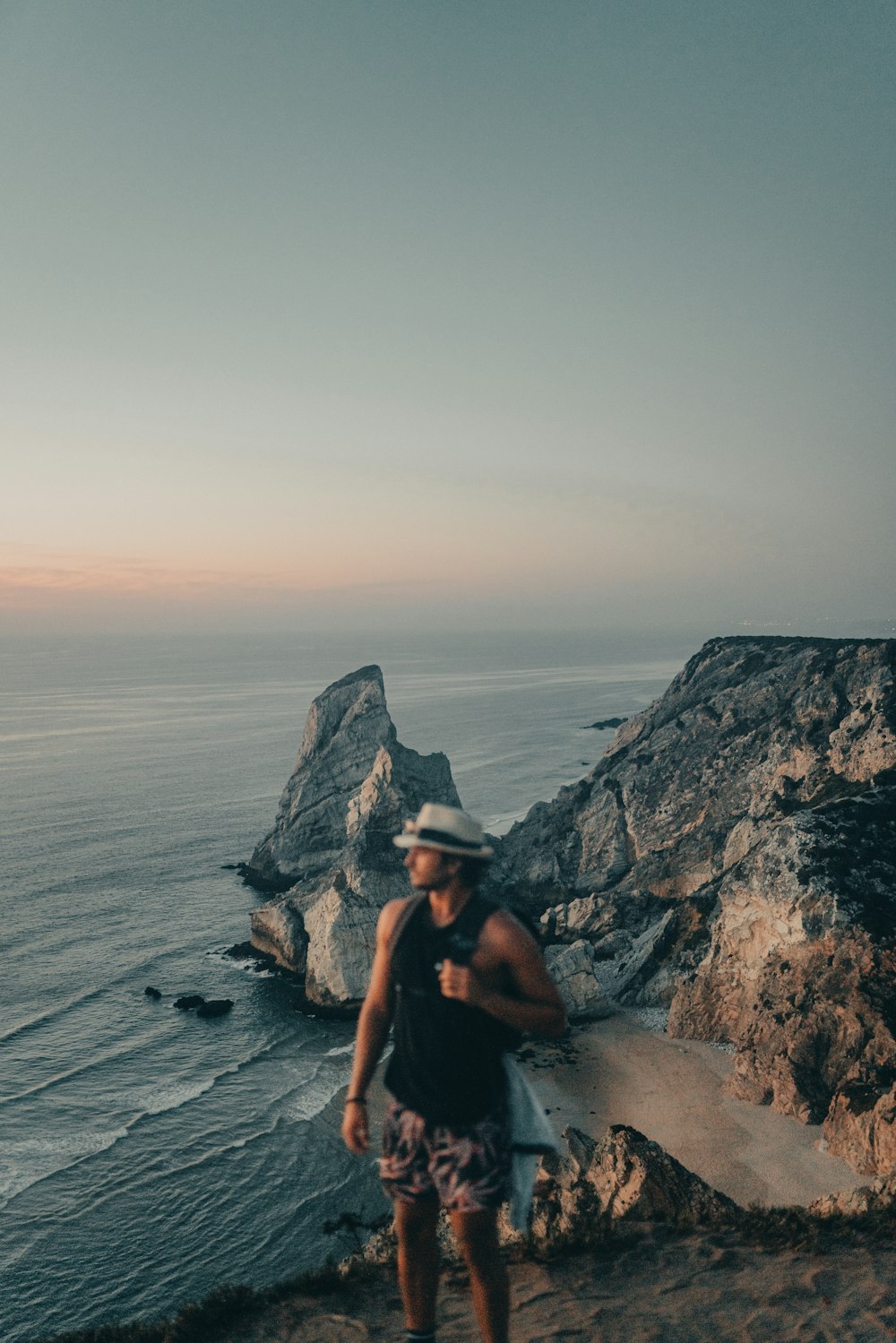 a man standing on a cliff overlooking the ocean