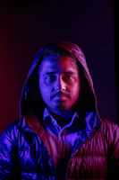 Model wearing a demon-inspired streetwear jacket under moody red lighting with subtle animated hover effect.