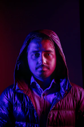 Model wearing a demon-inspired streetwear jacket under moody red lighting with subtle animated hover effect.