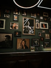 A warmly lit gallery wall featuring framed photographs in various sizes.