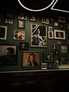 A collection of framed family portraits displayed on a rustic wooden wall
