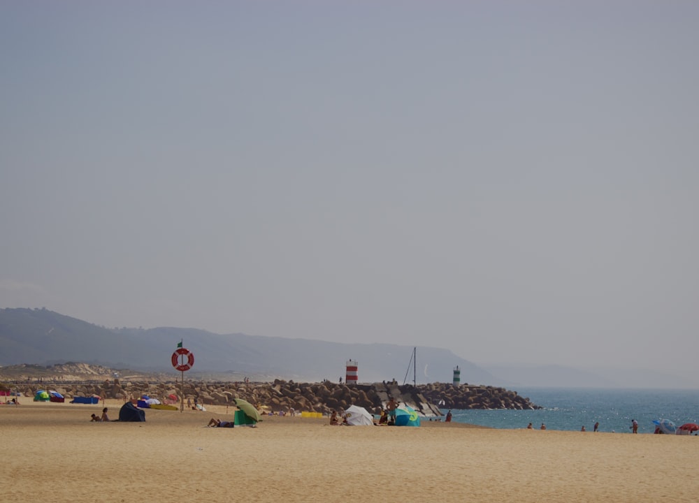 a group of people sitting on top of a sandy beach